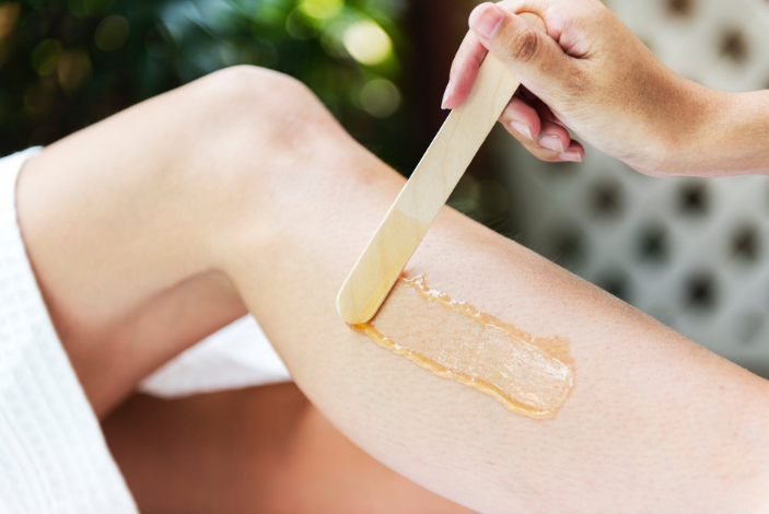 a person applying wax on the leg